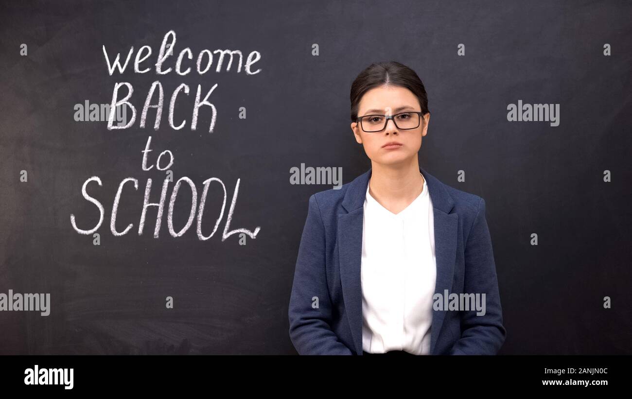 Unhappy disappointed teacher standing near blackboard, welcome back to  school Stock Photo - Alamy