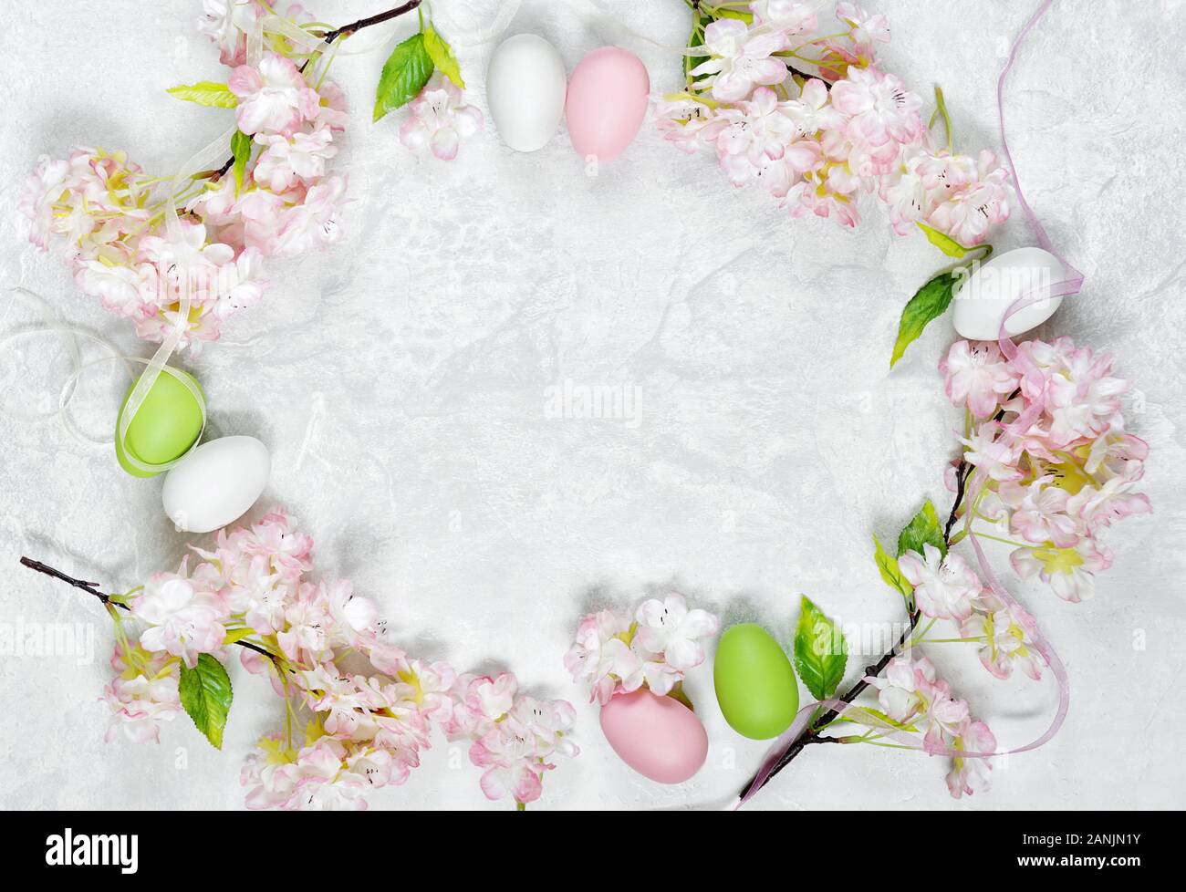 Beautiful delicate Easter composition with pink cherry flowers and multicolored Easter eggs Stock Photo
