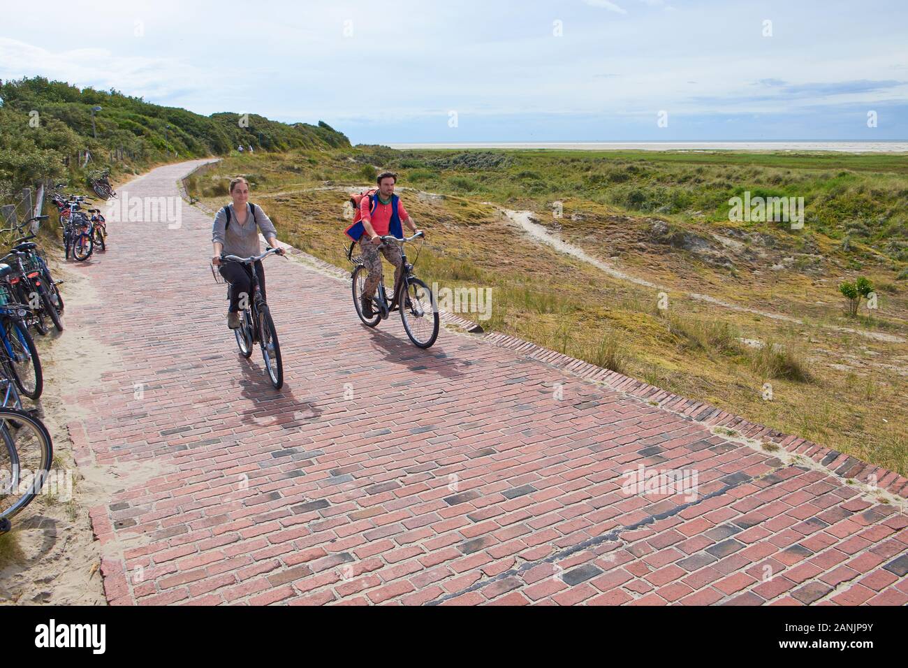 A male and female cyclist biking on Borkum Island Stock Photo