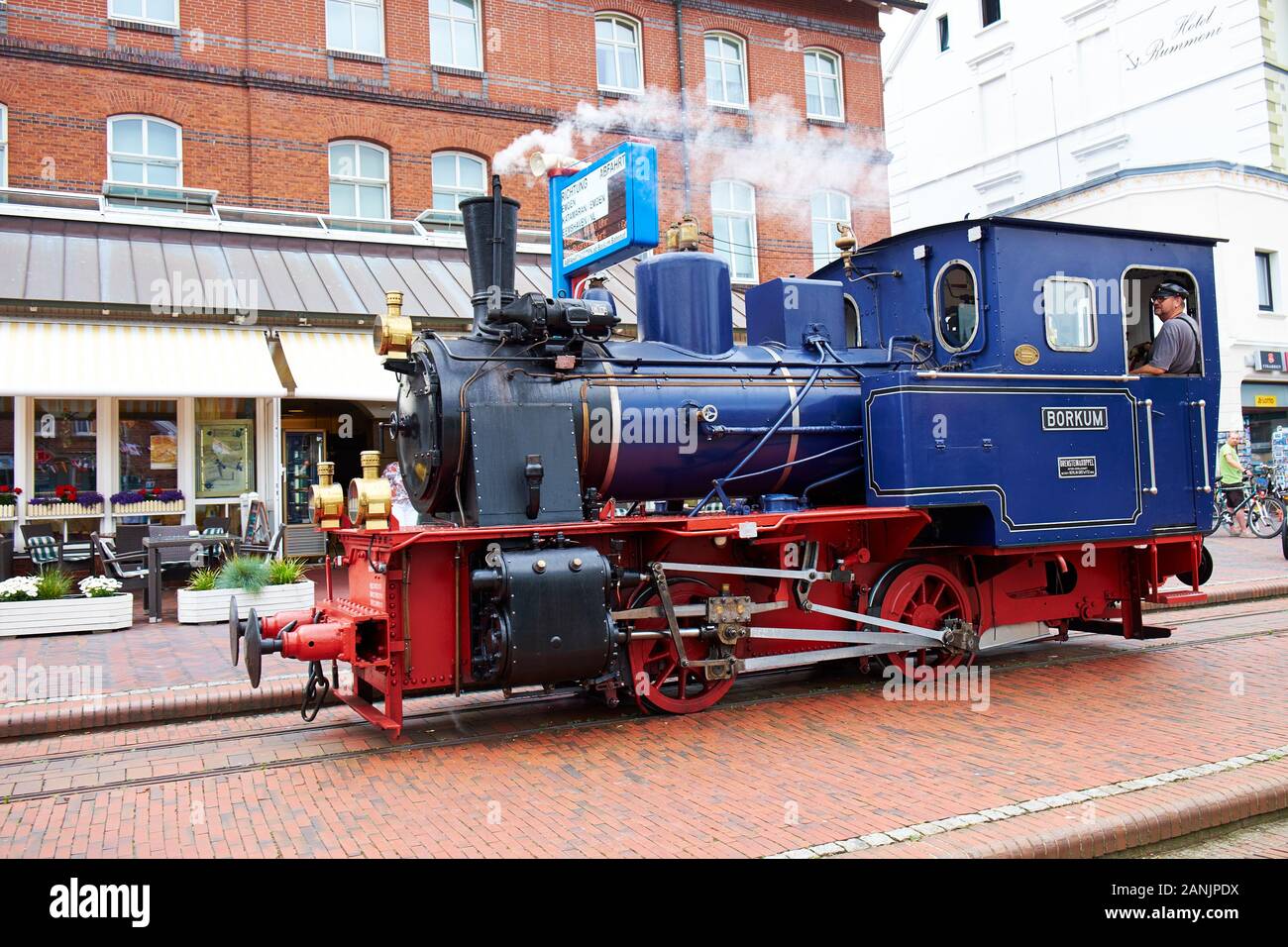 Blue narrow gauge steam locomotive at the train station in the town centre of Borkum Stock Photo