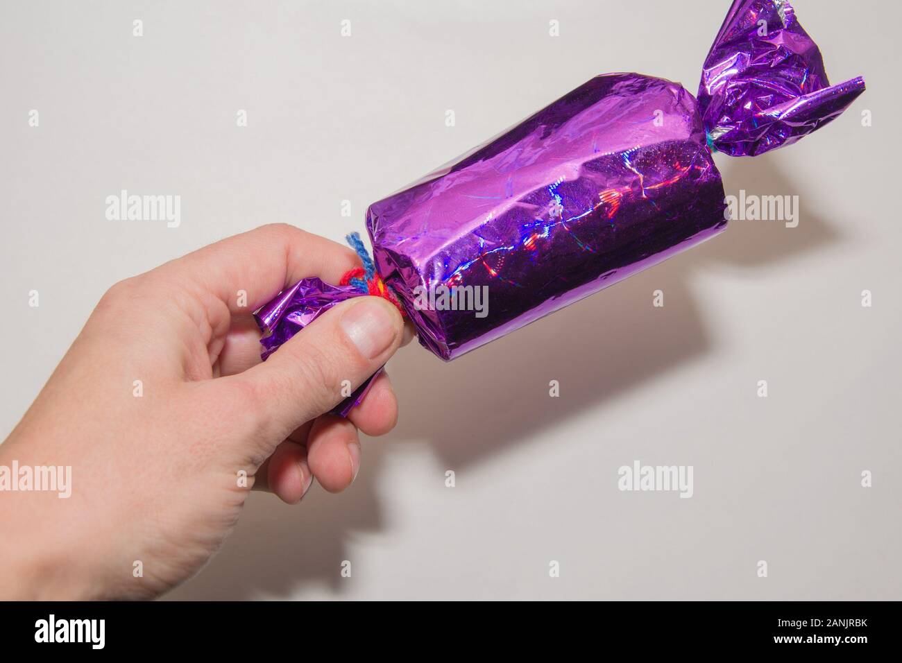 Man hand with big colorfull candy isolated on white background Stock Photo