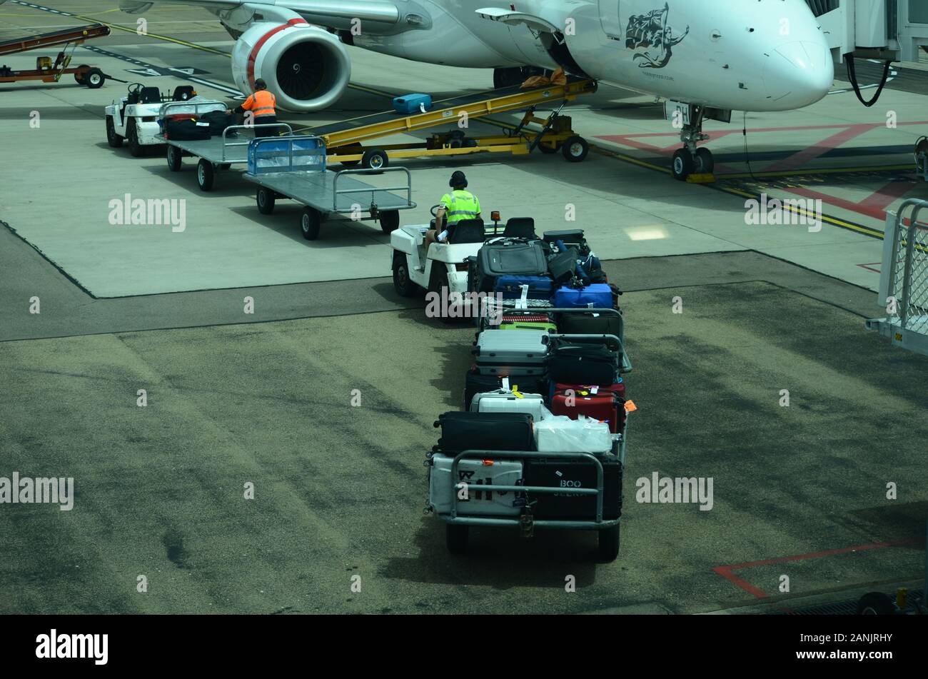 airport baggage handlers loading luggage and cargo onto passenger jet Stock Photo