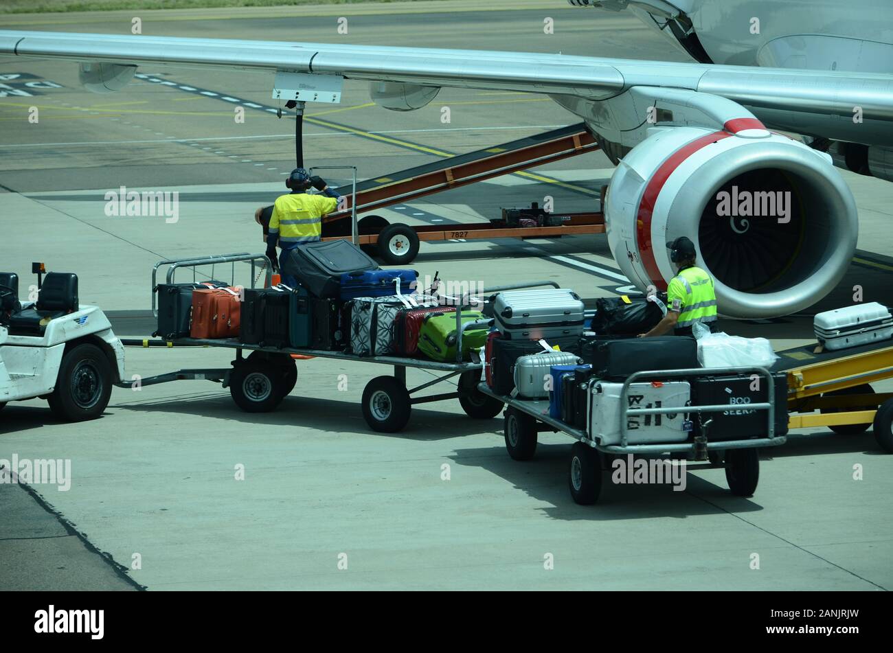 airport baggage handlers loading luggage and cargo onto passenger jet Stock Photo