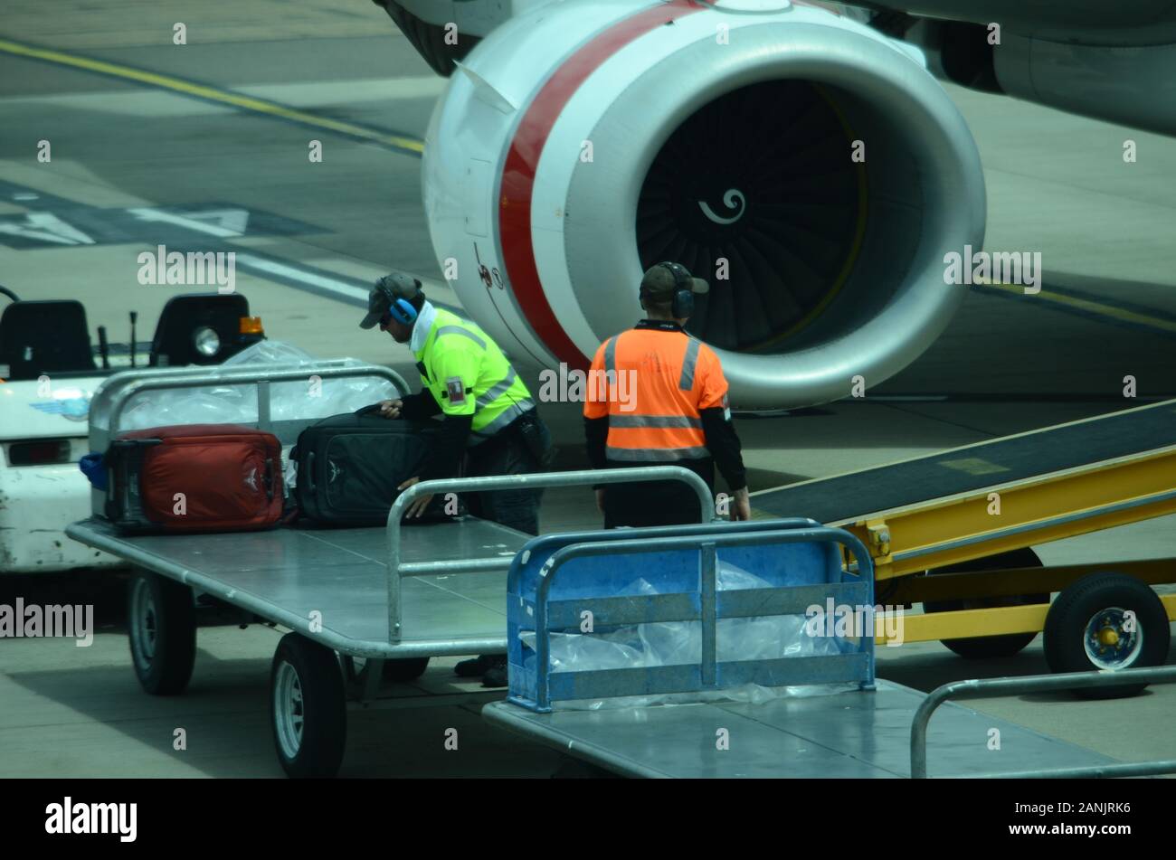 airport baggage handlers loading luggage and cargo onto passenger jet