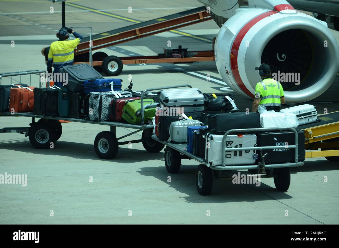 airport baggage handlers loading luggage and cargo onto passenger jet