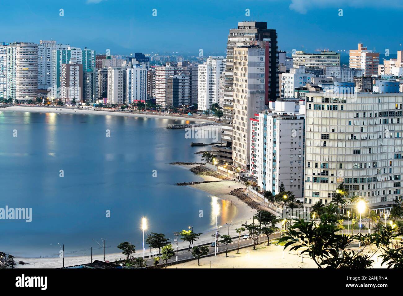 Urbanized coast, tall buildings near to the beach of a coastal city at dusk, when city lights begin to turn on. Paulista coast, Sao Vicente city - SP Stock Photo