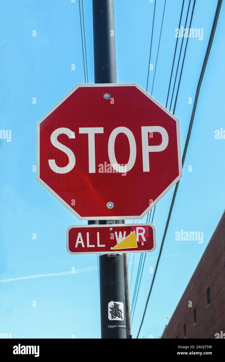 Urban stop sign with small sign underneath reading All War and stickers Not for Sale and Stop Facisists Stock Photo