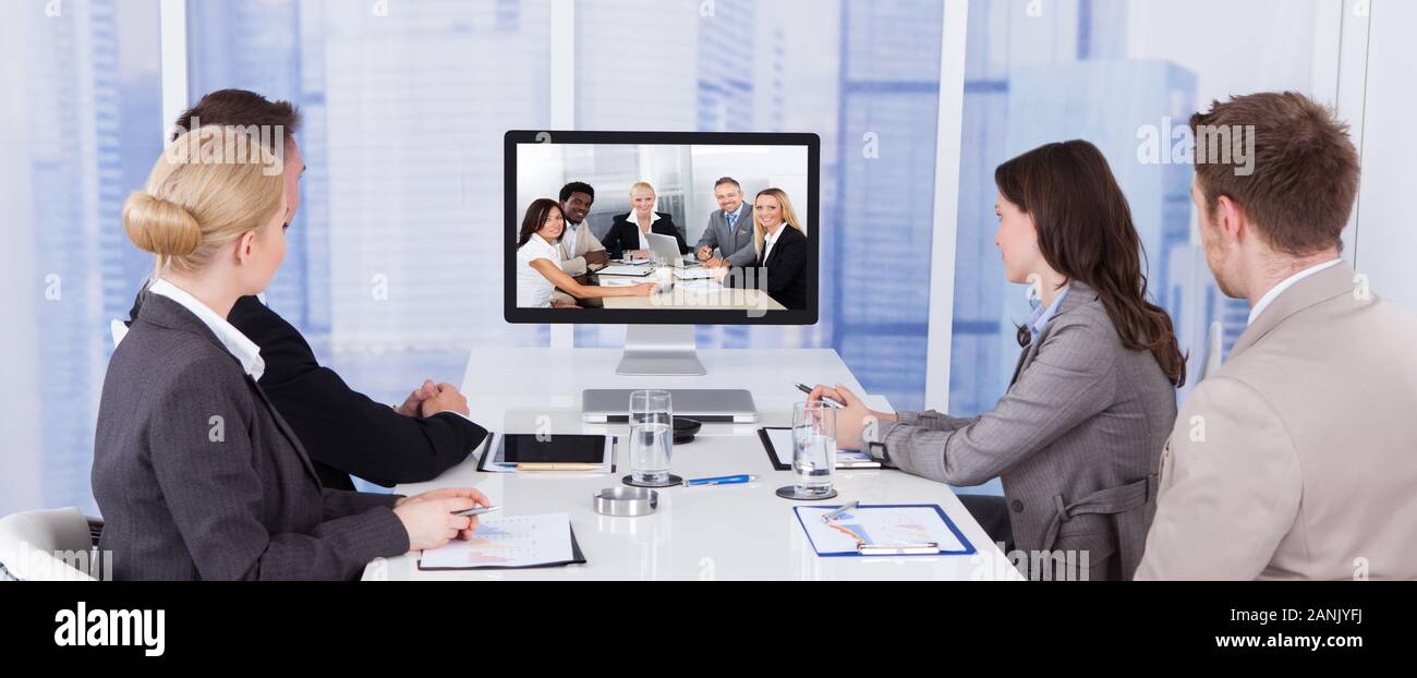 Business People In Video Conference At Meeting Table Stock Photo Alamy
