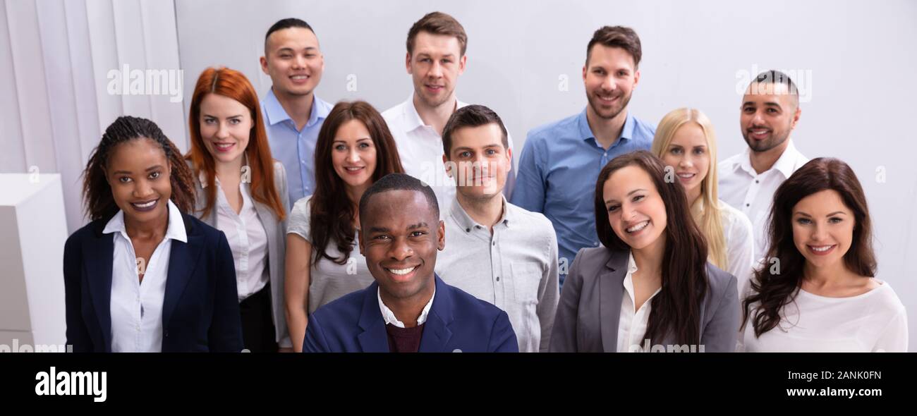 Group Of Young Successful Multi-ethnic Businesspeople Standing In Office Looking At Camera Stock Photo