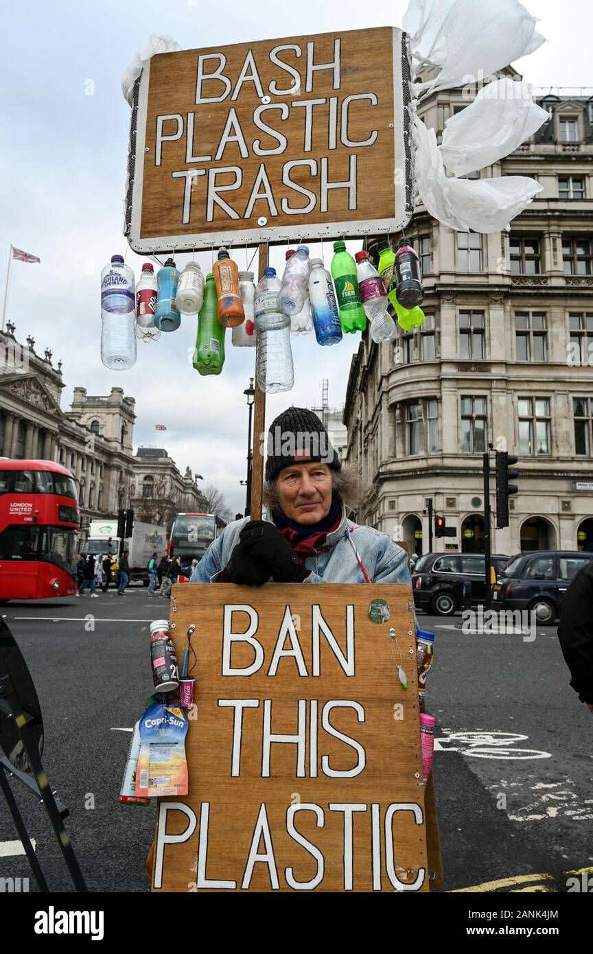 An environmental activist campaigning against  plastic pollution with placards 'Bash Plastic Trash' and 'Ban this Plastic Poison'. Stock Photo
