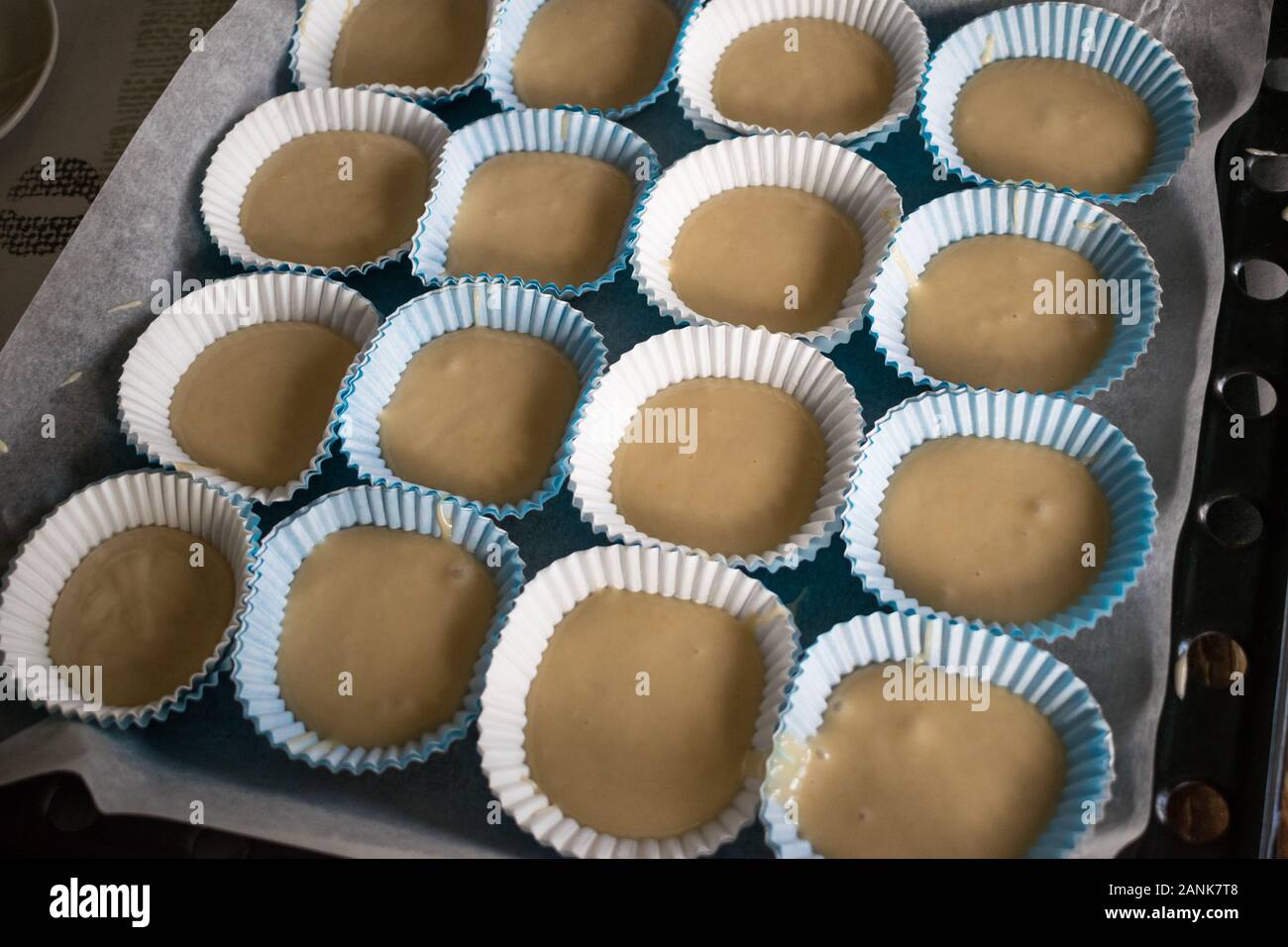 cupcake paper molds filled with dough ready to put in the oven Stock Photo  - Alamy