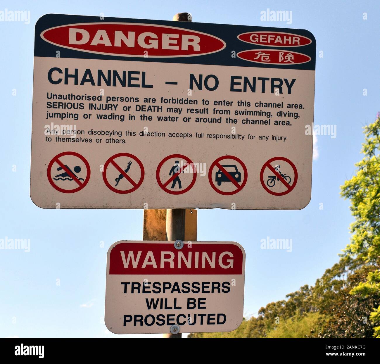 A warning sign showing dangers of an irrigation channel which has fast flowing water. Stock Photo