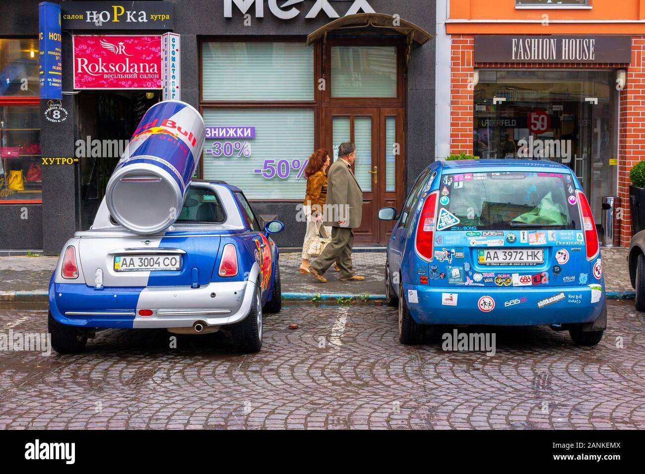 Uzhhorod, ukraine - 14 JUL, 2013: Red Bull mini cooper publicity car with a can of energy drink behind. fancy car tuning used for promotion. wet adver Stock Photo