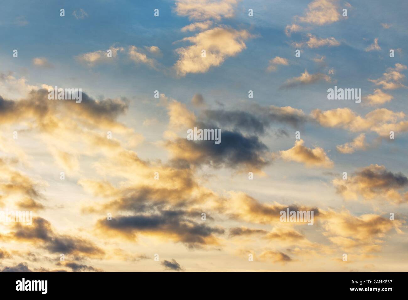 golden clouds on a blue sky at sunset. beautiful nature background. wonderful atmosphere scenery in the evening. cloudy forecast in the evening concep Stock Photo