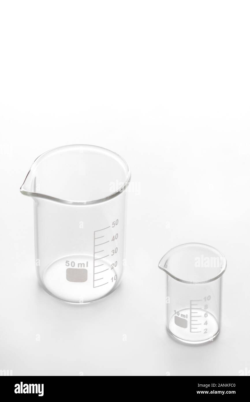 two empty transparent glass beakers 50 ml and 10 ml on a white background, showing comparison of size and volume Stock Photo