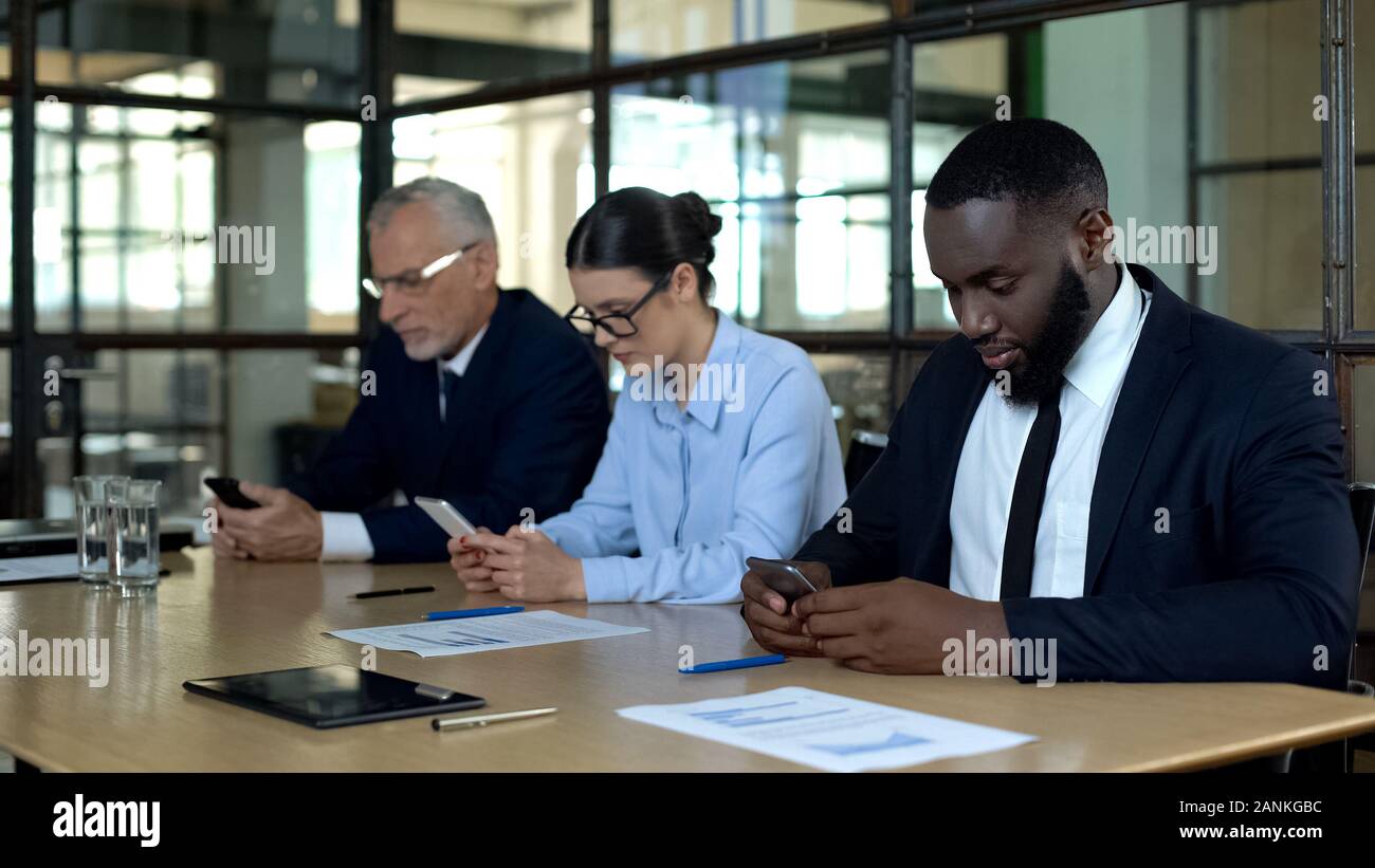 Serious managers using smartphones, business messenger application, technology Stock Photo