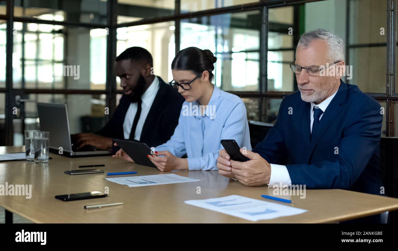Multiracial group of office employees working smartphone, tablet and laptop Stock Photo