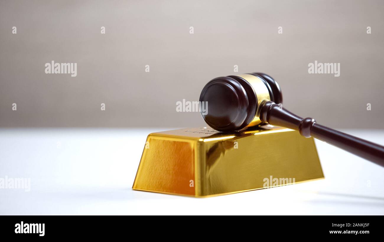 Gavel lying golden bar, corrupted judicial system, court bribery, dishonesty Stock Photo