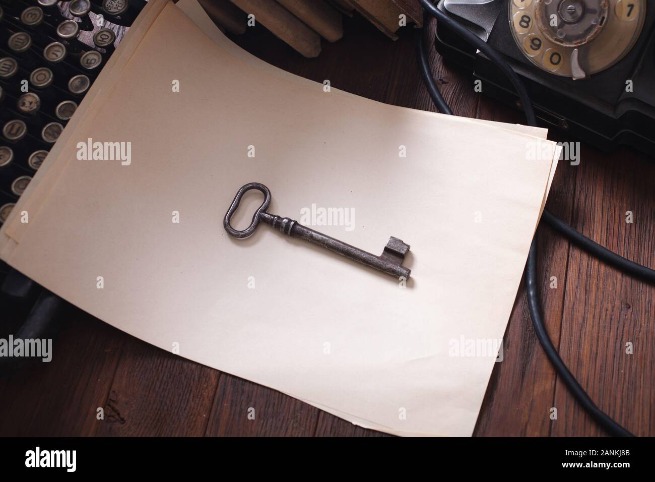 Old retro vintage typewriter and blank sheet of paper with key on wooden table Stock Photo