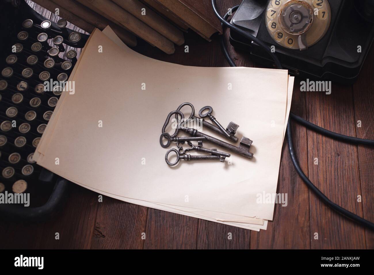 Old retro vintage typewriter and a blank sheet of paper with key on wooden table Stock Photo