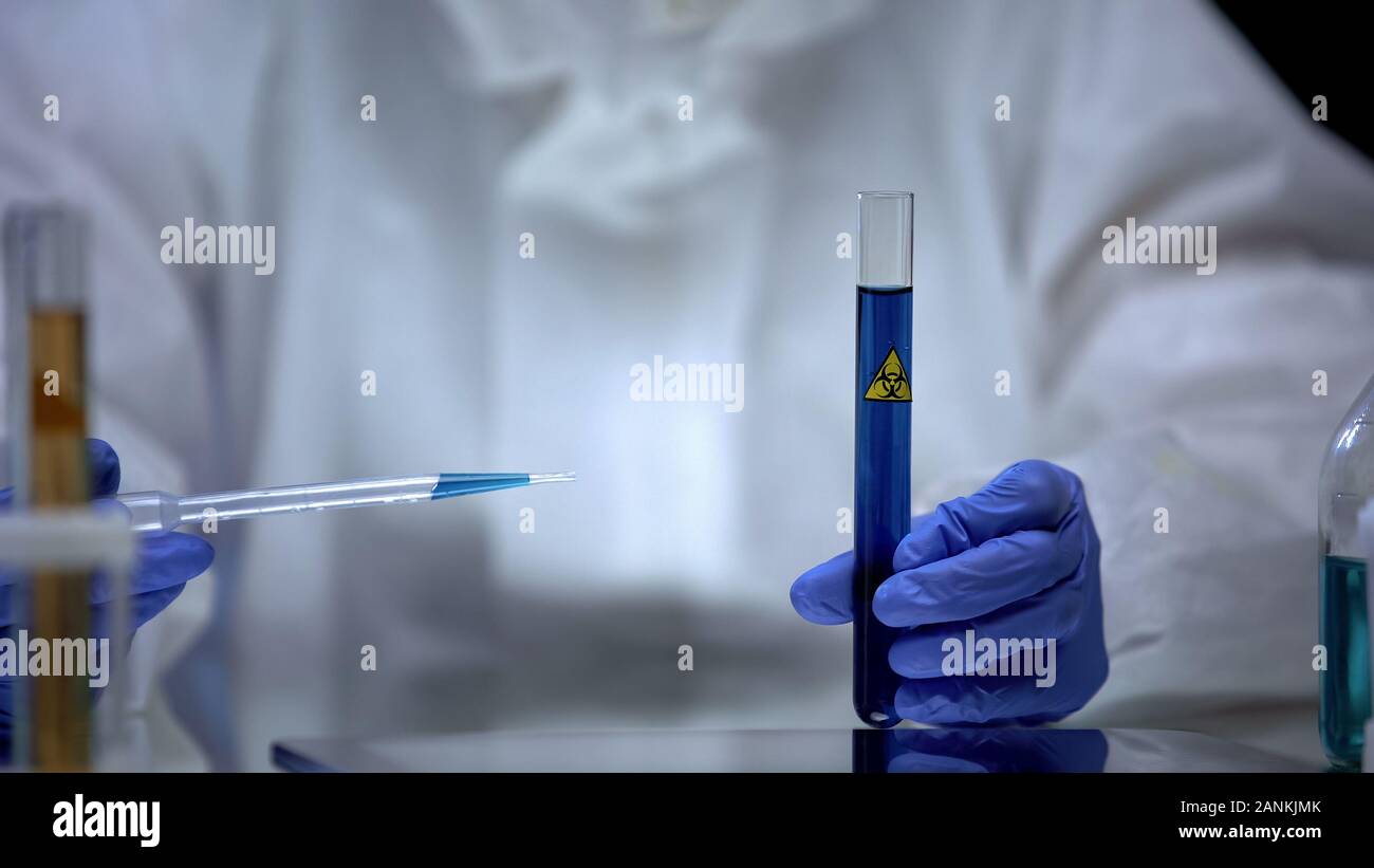 Scientist of toxic lab examining sample of blue ionizing radiation