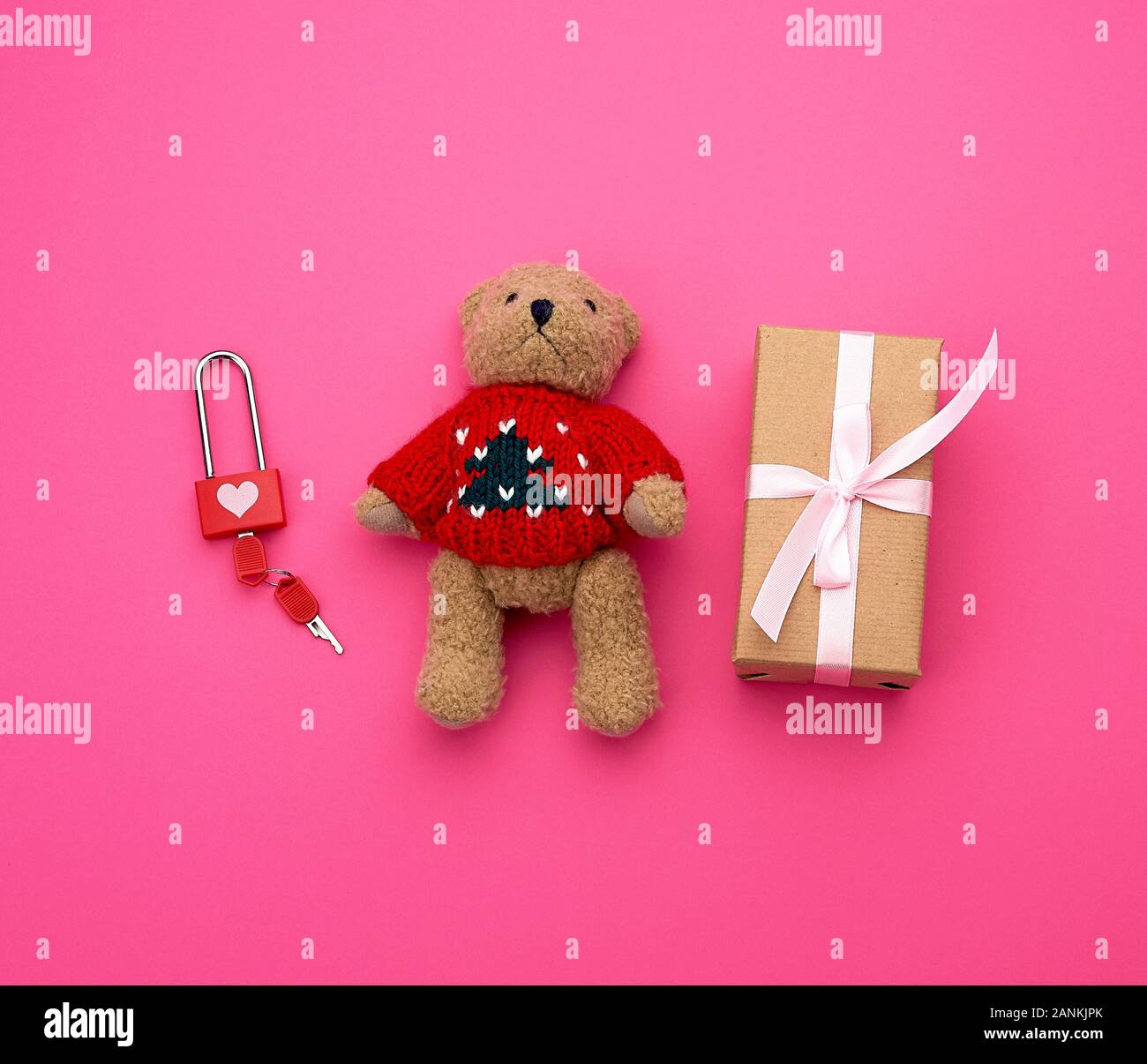 brown gift box and little brown teddy bear on a pink background, top ...
