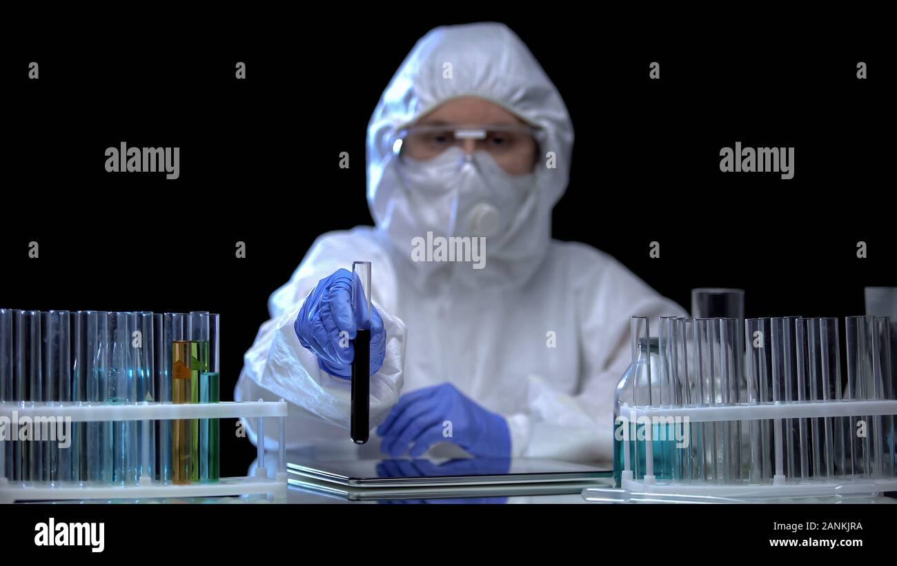 Worker of laboratory showing sample of toxic ground before camera