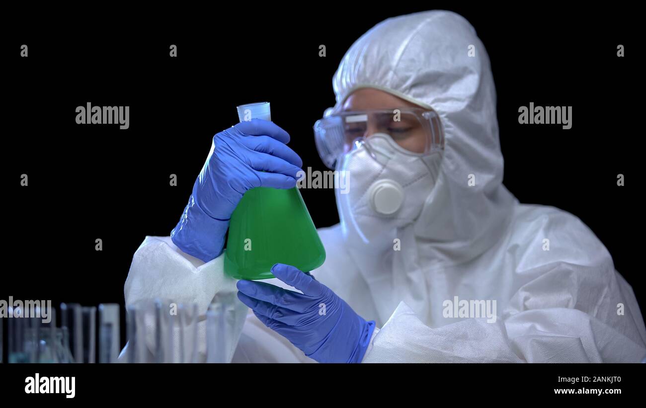 Illegal lab worker holding flask with radioactive liquid, water poisoning, crime Stock Photo
