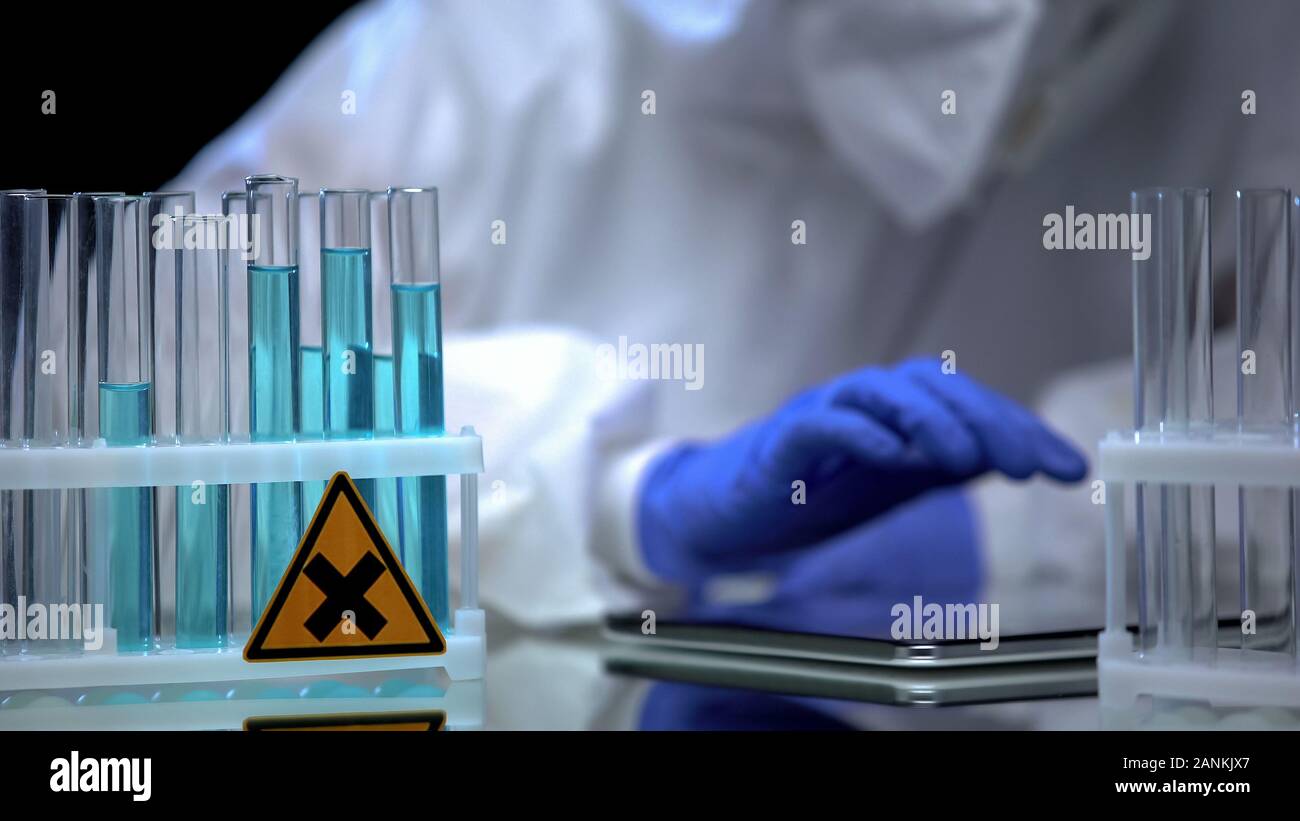 Lab Testing Need Signs Laboratory worker examining test tubes with harmful sign making notes ...