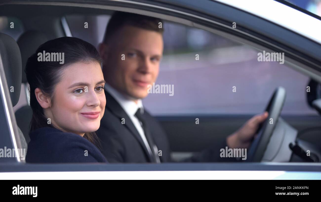 Young couple sitting happily in car after romantic date, loving relationship Stock Photo