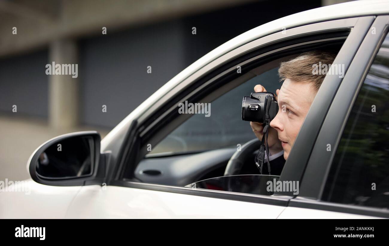 Reporter secretly taking photo sitting in auto, spying paparazzi, exclusive Stock Photo
