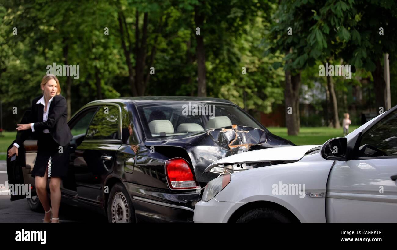 Getting Wrecked Shocked female driver getting out car looking at wrecked cars on road ...