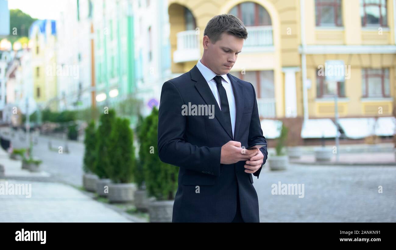 Businessman sending message as walking to work, busy lifestyle, workaholic Stock Photo