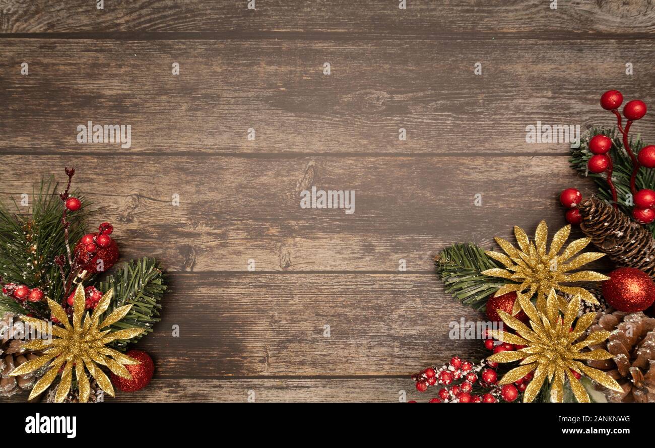Christmas fir tree with gold glitter poinsettie and red ornaments on wooden background. Flatlay, top view, copy space. Stock Photo