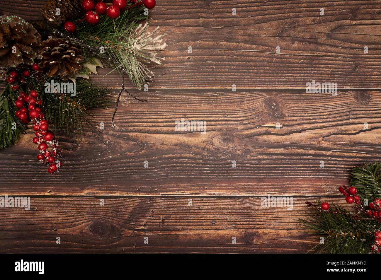 Christmas fir tree with berries pinecones and snow on wooden background. Flatlay, top view, copy space. Stock Photo