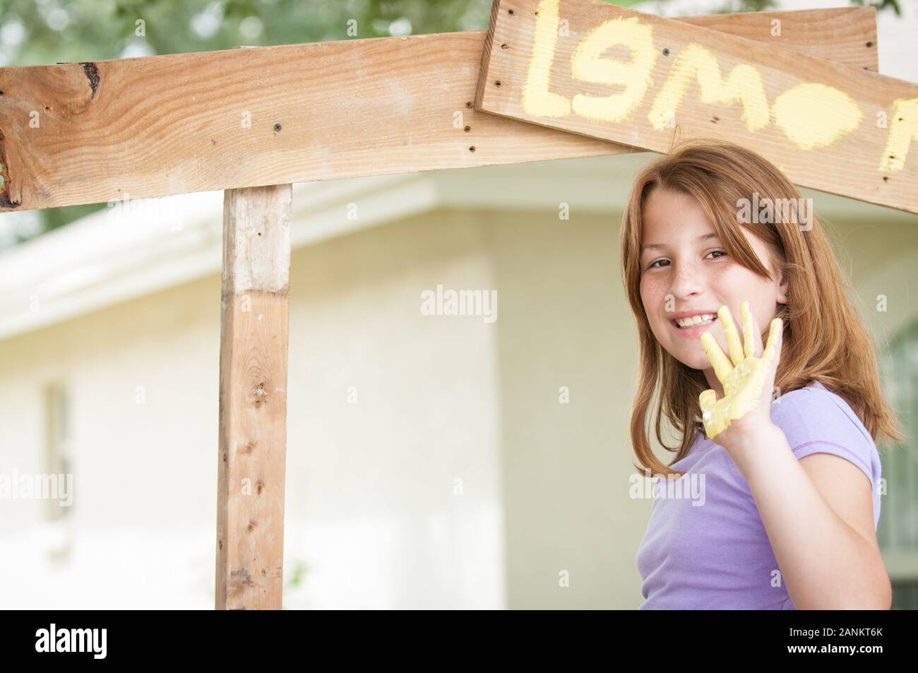 Young girl painting a lemonade stand Stock Photo
