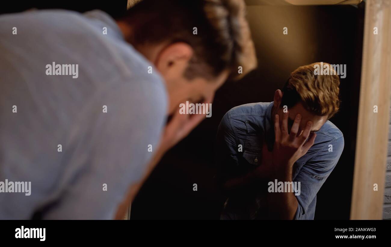 Young male actor closing face with hands, rehearsing role in front of ...