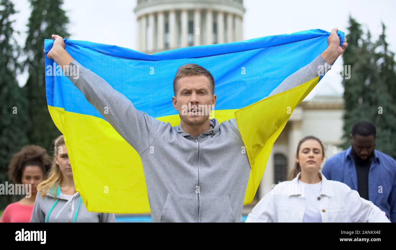 Activists raising Ukrainian flag chanting slogan, independence rally, patriotism Stock Photo