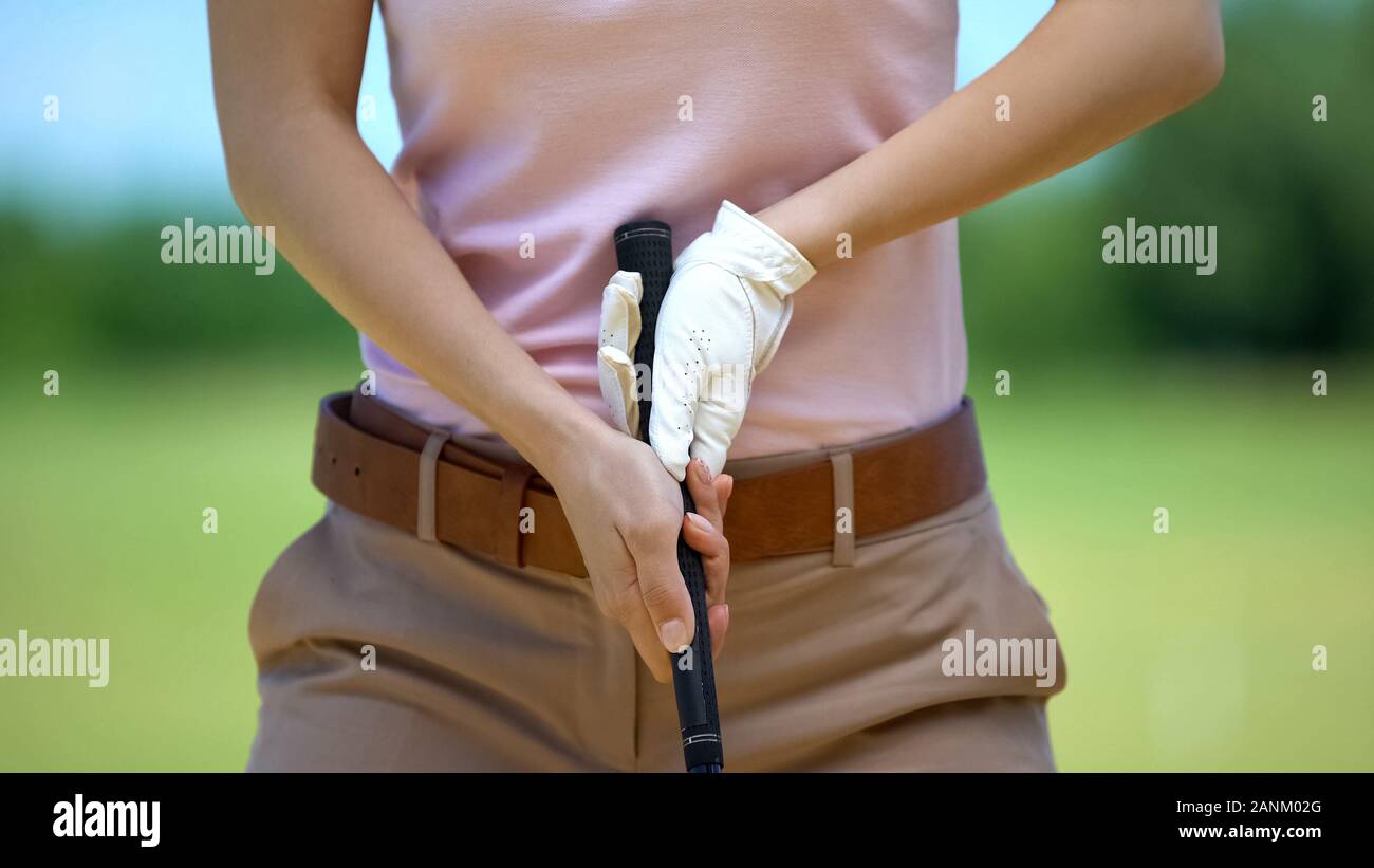 Female beginner golf player training in basic ball position, elite
