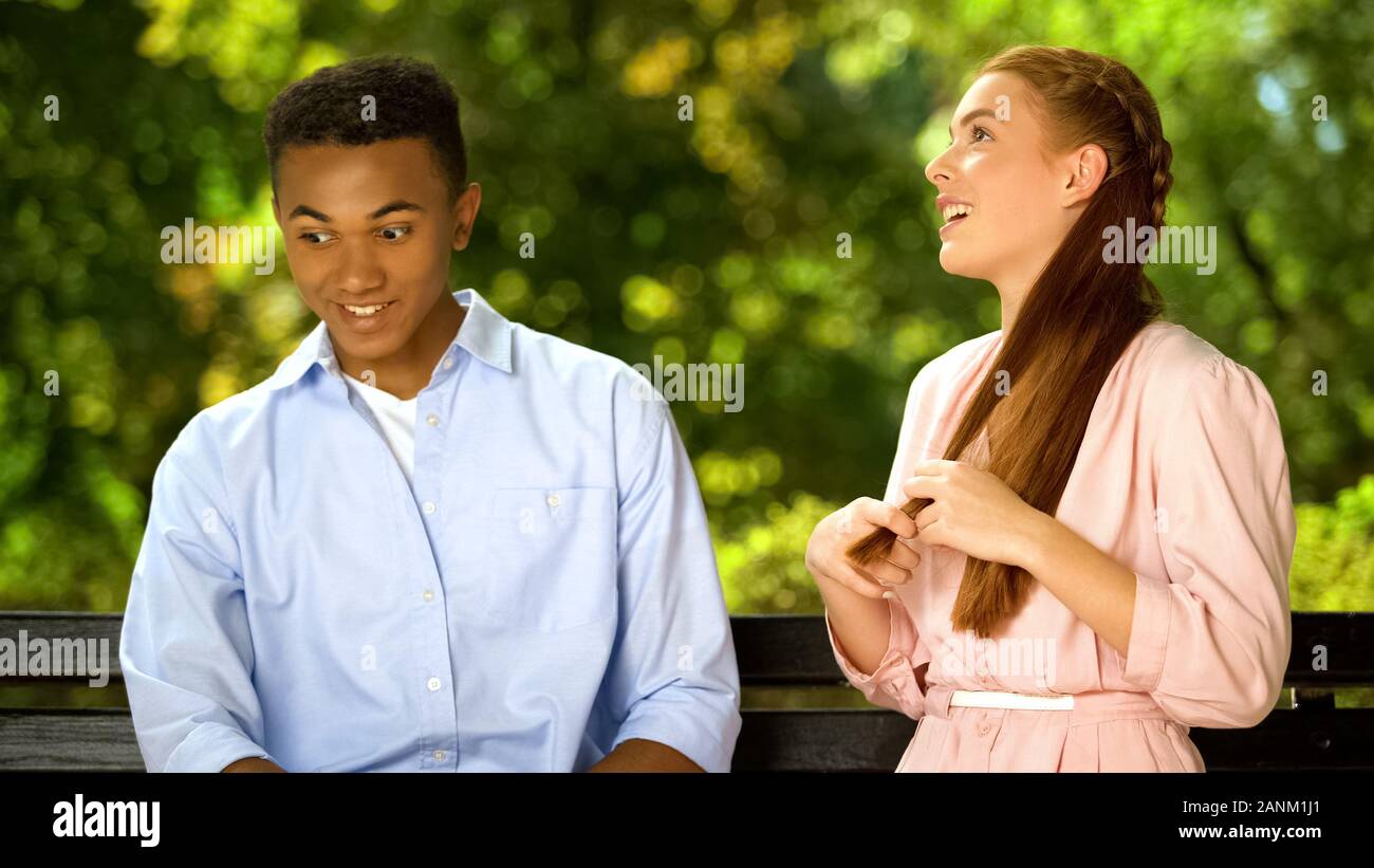 Multiracial boyfriend listening to annoying girlfriend, shocked by chatty girl Stock Photo