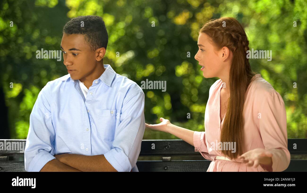 Dissatisfied girl making complaint to her shocked boyfriend, relationship crisis Stock Photo