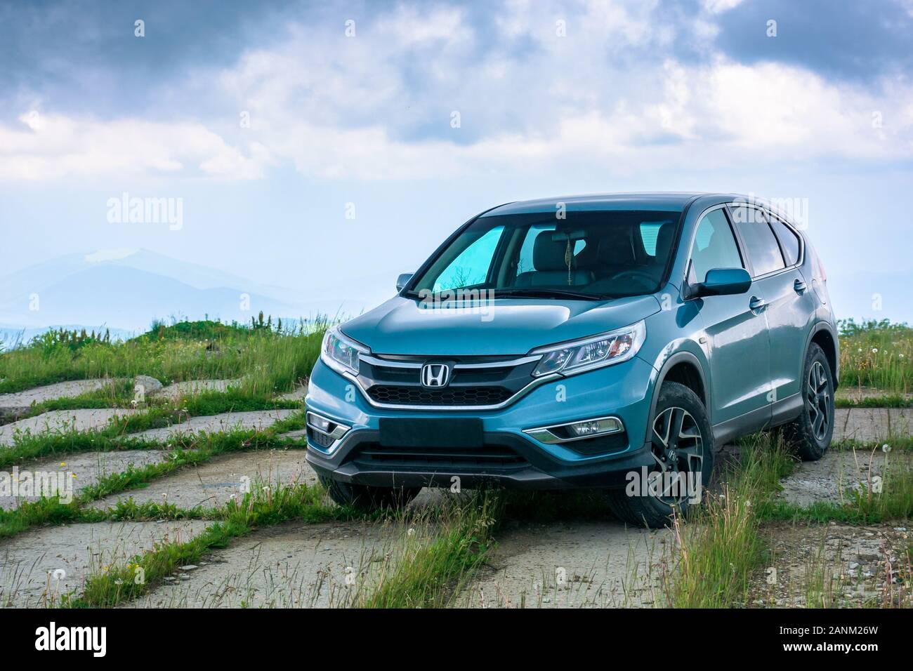 mnt. runa, ukraine - JUN 22, 2019: blue suv on a paved meadow. popular AWD vehicle in nature scenery. stormy weather with cloudy sky. take your family Stock Photo