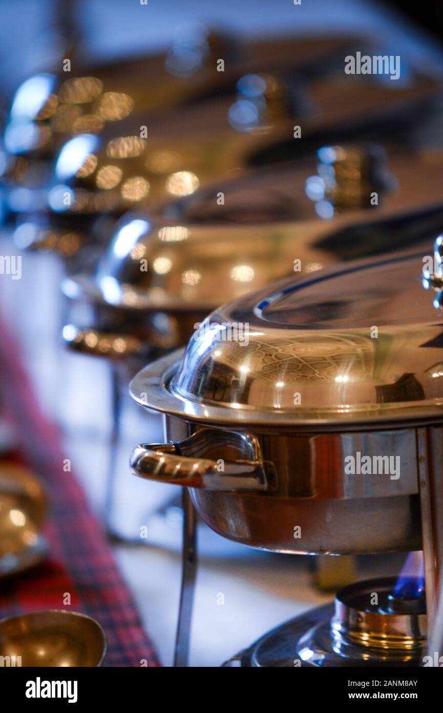 Keeping the food warm with chafing dishes (from the French chauffer, "to make warm") at a buffet Stock Photo
