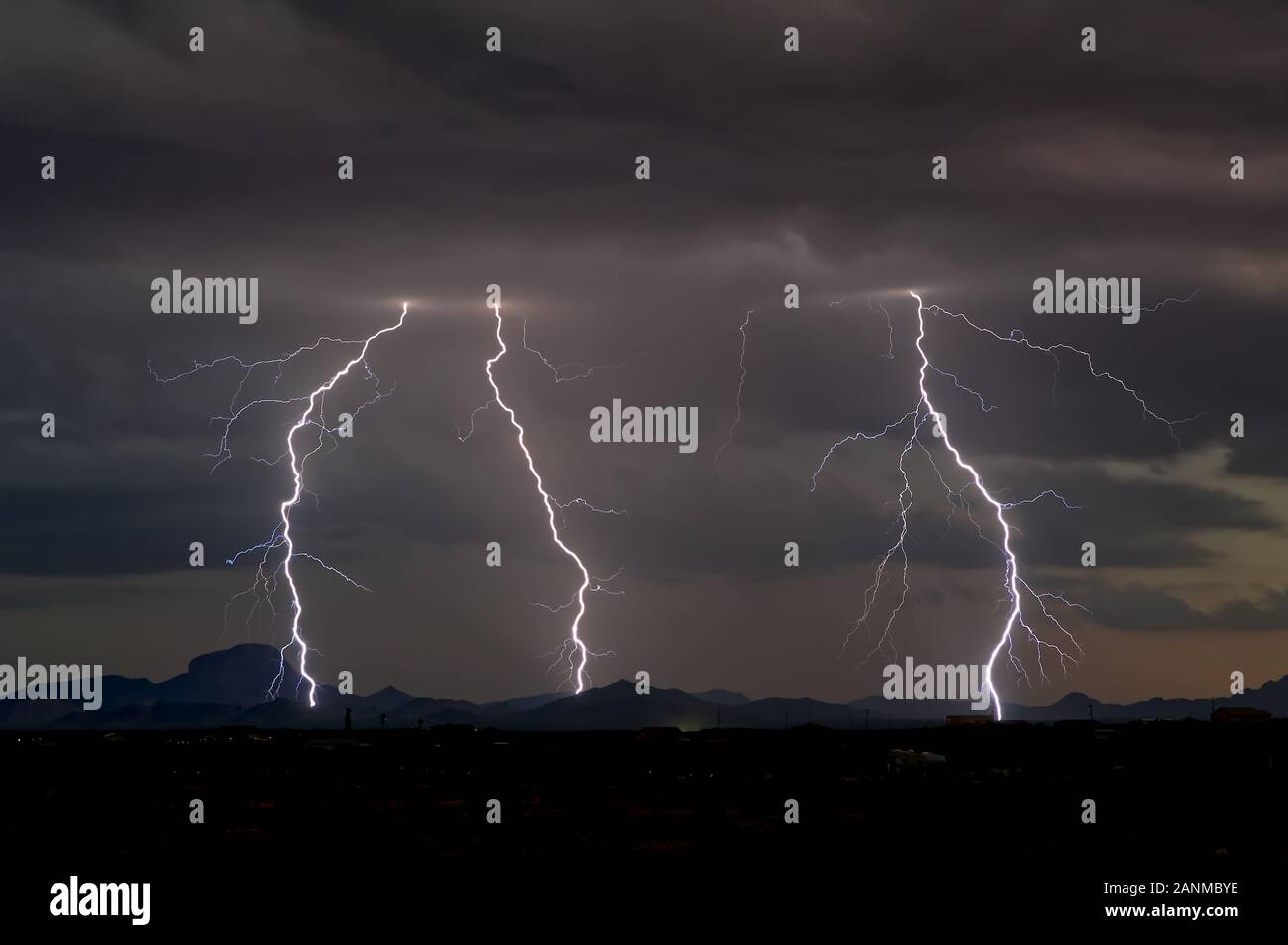 A 2014 Monsoon Lightning storm over the Gila Bend Mountains of southwestern Arizona just after sunset with only the twilight on the horizon. Stock Photo