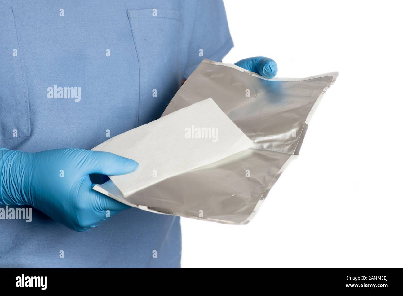 Nurse removes packaging from lidocaine wound dressing prior to use. Stock Photo