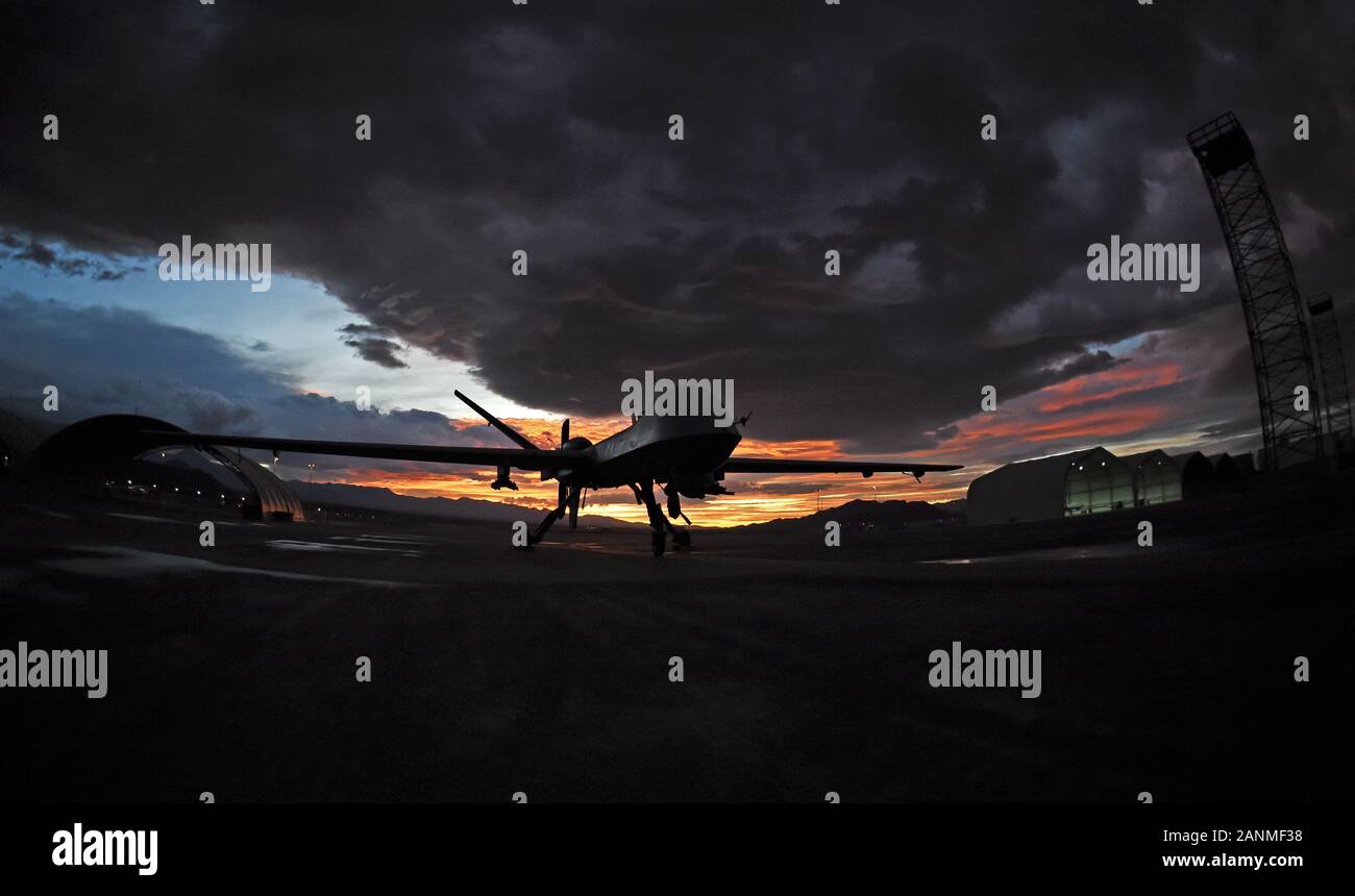 An MQ-9 Reaper sits on the flight line as the sun sets at Creech Air ...