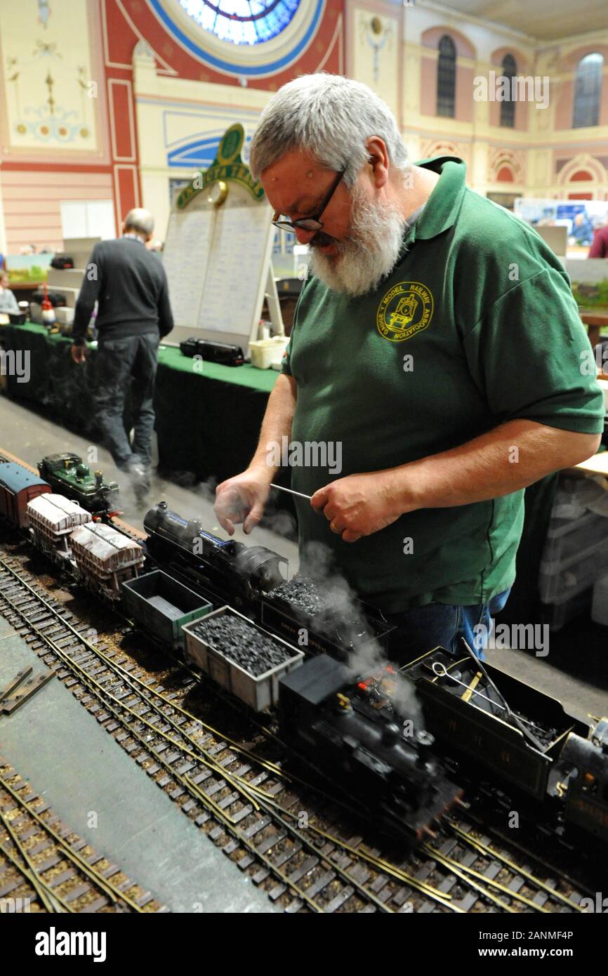 An enthusiast preparing a 16mm narrow gauge train at the London Model Engineering Exhibition which opened today at Alexandra Palace, London.  The show is one of the largest modelling exhibitions in the UK, blending the full spectrum of model creation from traditional model engineering, steam locomotives and traction engines through to more modern gadgets and ‘boys toys’ including trucks, boats, aeroplanes and helicopters.  Over 45 national and regional modelling clubs and societies and associations will be displaying their member’s work and competing to win the prestigious Society Shield. In t Stock Photo