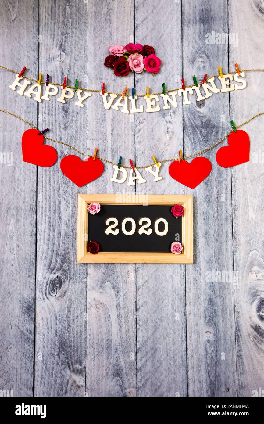 Happy Valentines Day With Red Hearts And Flowers On A Wood Background With 2020 On A Chalkboard Vertical Stock Photo Alamy