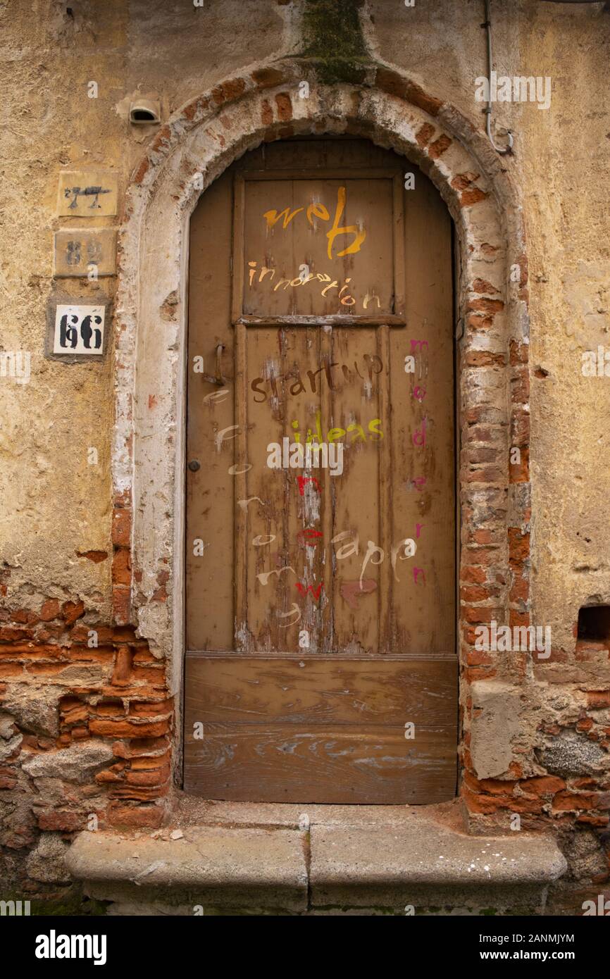 contrast of modernity and antiquity with some written on an old door Stock Photo