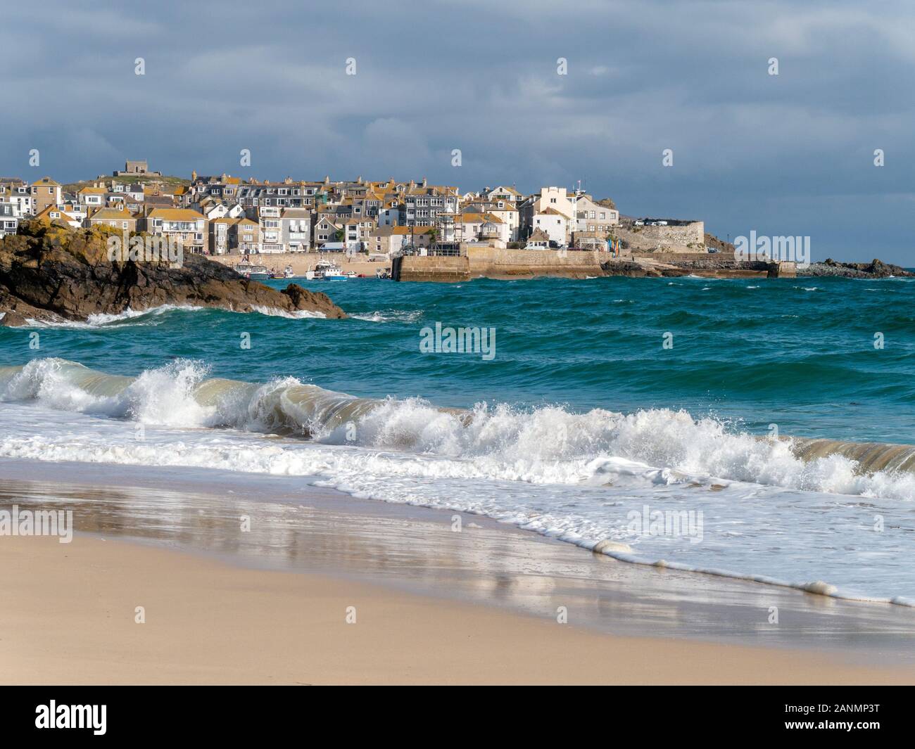 The seaside town of St. Ives a seen over the waves and sea surf  of sandy Porthminster Beach, Cornwall, England, UK. Stock Photo